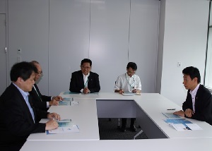 AMEDの取り組みについて末松理事長から説明を受ける西村副大臣